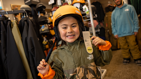 young snowboarder trying on a helmet
